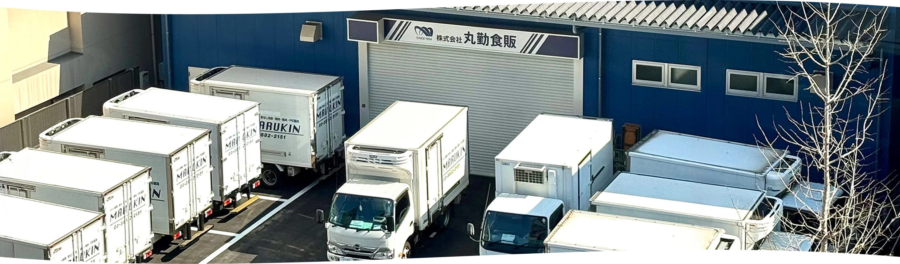 丸勤食販の社屋と配送車両